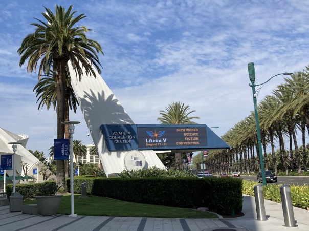 Blue sign surrounded by palm trees in front of Anaheim Convention Center advertising LAcon V, the 84th World Science Fiction Convention